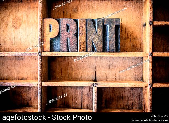 The word PRINT written in vintage wooden letterpress type in a wooden type drawer