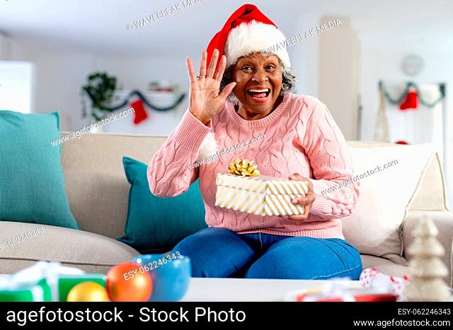 Happy senior african american women wearing santa claus hat and waving