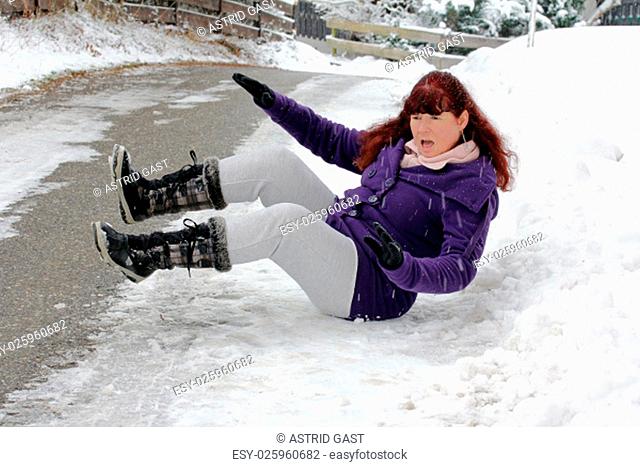 risk of accidents in winter - a woman slipped on a snow slippery road