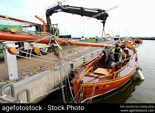 27 October 2020, Mecklenburg-Western Pomerania, Dierhagen: Peter Zobel, harbour master, is in the Boddenhafen unrigging the old Zeesenboote