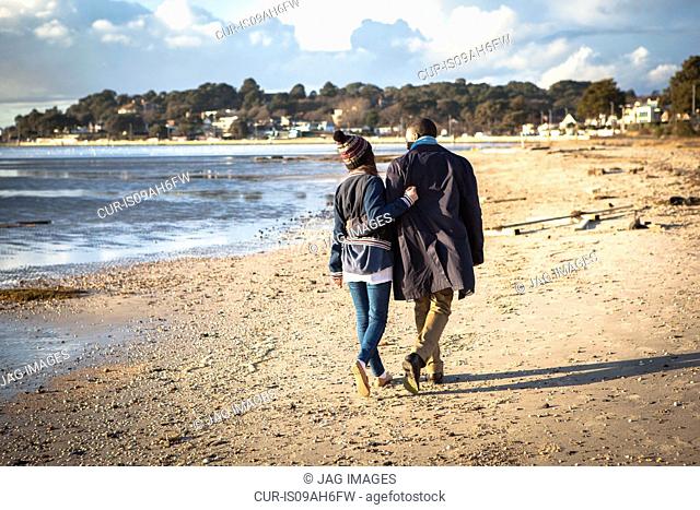 Romantic young couple strolling on the beach