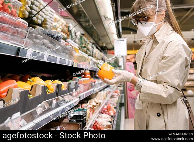 Woman with face mask and disposable gloves in a supermarket