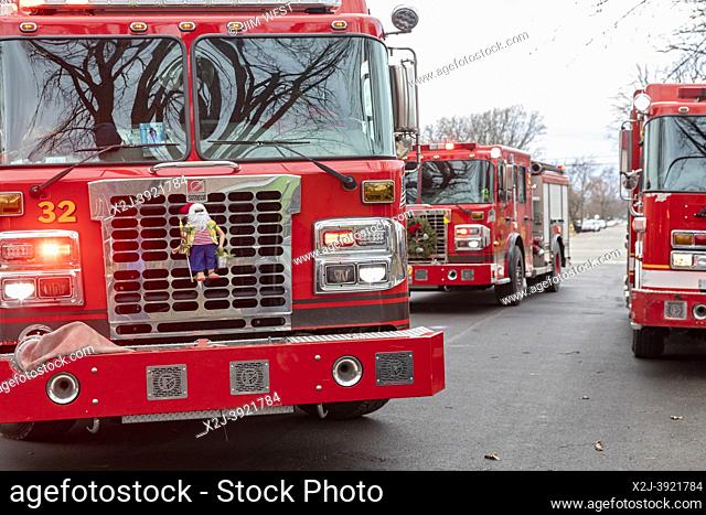 Detroit, Michigan - A Santa Claus doll and a wreath decorate fire trucks as firefighters battle a house fire a few weeks before Christmas