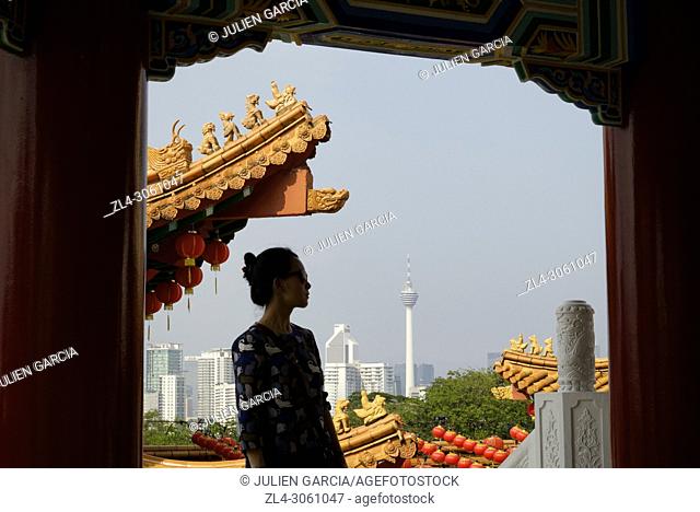 Malaysia, Selangor State, Kuala Lumpur, woman at Thean Hou Chinese Temple, KL tower (Menara Kuala Lumpur) in the background, Model Released