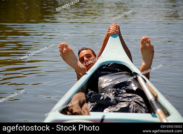 Canoeing, swimming in the river, grabbing the front of the boat