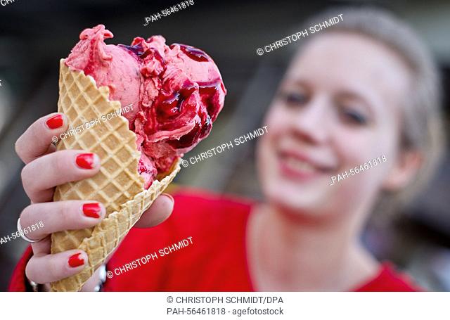 Esther holds up a cone of Balsamic-Strawberry ice cream at the 'Christina' ice cream parlour in Frankfurt/Main, Germany, 06 March 2015