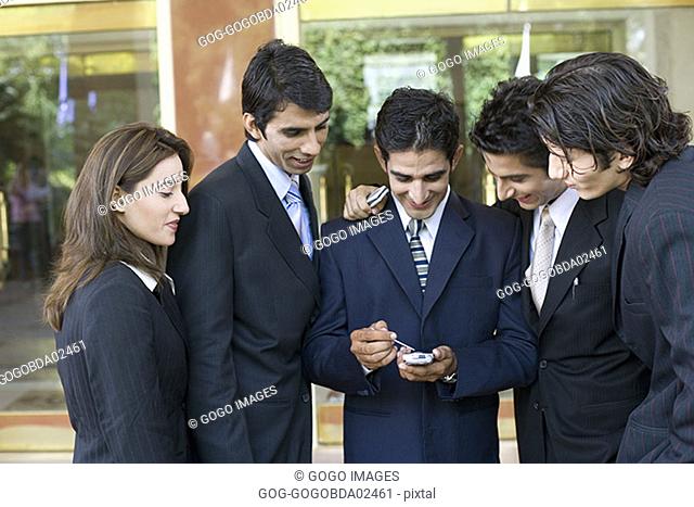 Businesspeople looking at electronic organizer