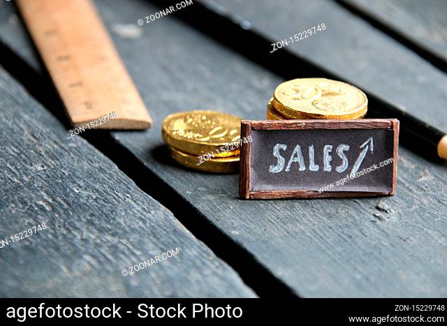 sales tag and piles of gold coins on a vintage table