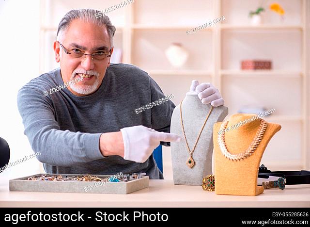 White bearded old jeweler at workshop