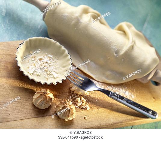 Pastry dough, tart tin, rolling pin and fork