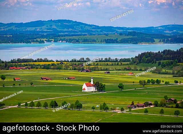 View of the Bavarian 17th century baroque Roman Catholic church St. Coloman and the Forggensee lake in the background, Schwangau, Bavaria