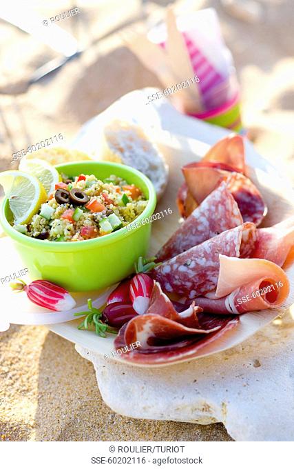 Picnic on the beach with cold cuts and tabbouleh