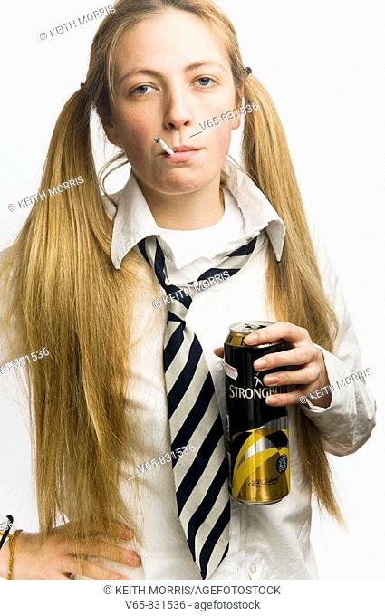 Teenage schoolgirl wearing school uniform smoking cigarette and drinking a can of cider