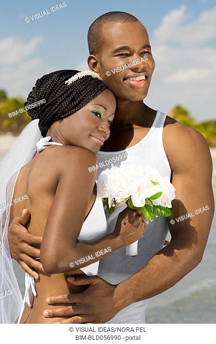 African bride and groom hugging