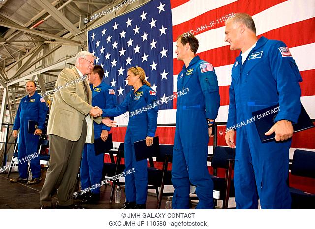NASA's Johnson Space Center (JSC) director Michael L. Coats shakes hands with Canadian Space Agency astronaut Julie Payette, mission specialist