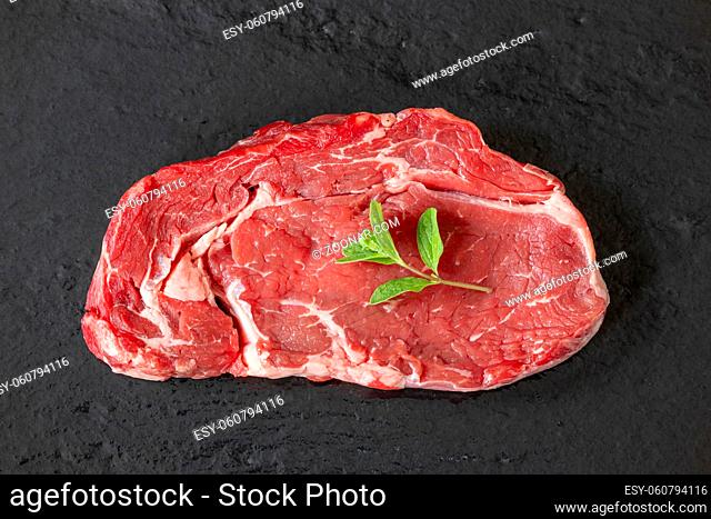 overview of a raw steak on black slice