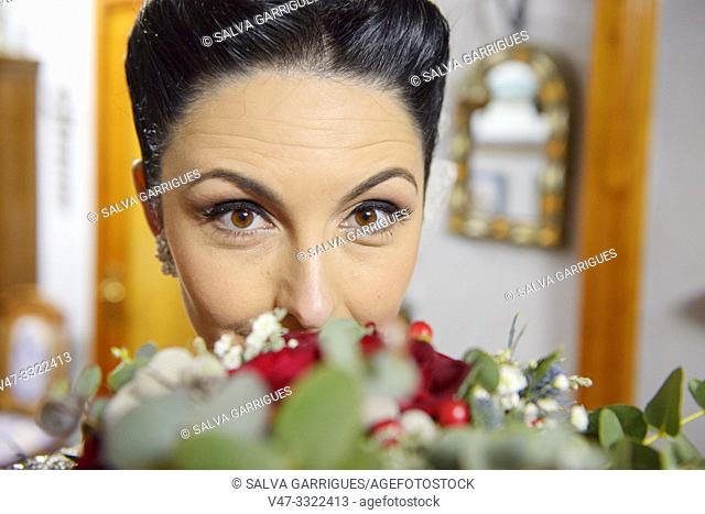 Portrait of the bride while smelling the wedding bouquet, the day of the wedding, Carcaixent, Valencia, Spain
