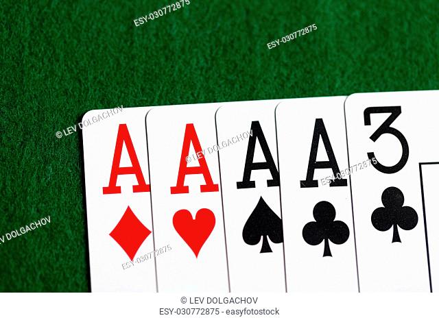 casino, gambling, games of chance, hazard and entertainment concept - poker hand of playing cards on green cloth