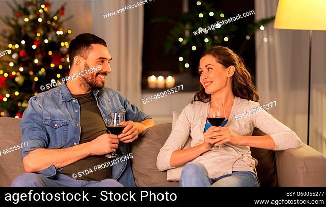 happy couple drinking wine at home on christmas