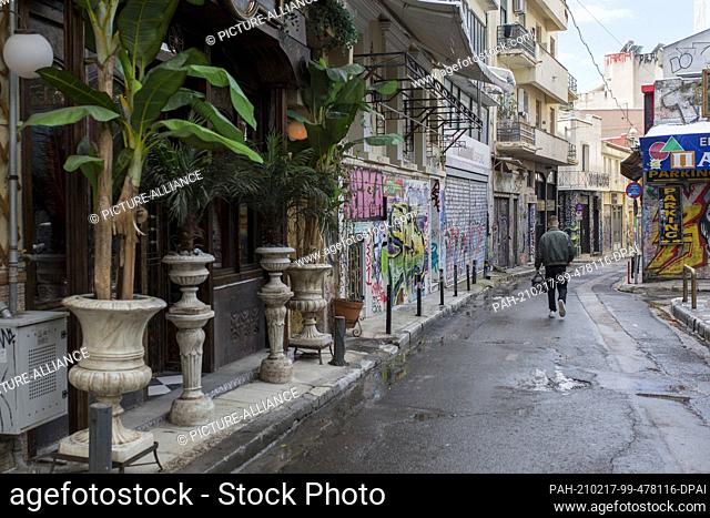 17 February 2021, Greece, Athen: A delivery driver walks past closed shops in the Monastiraki district of Athens. A strict lockdown has been in effect for the...