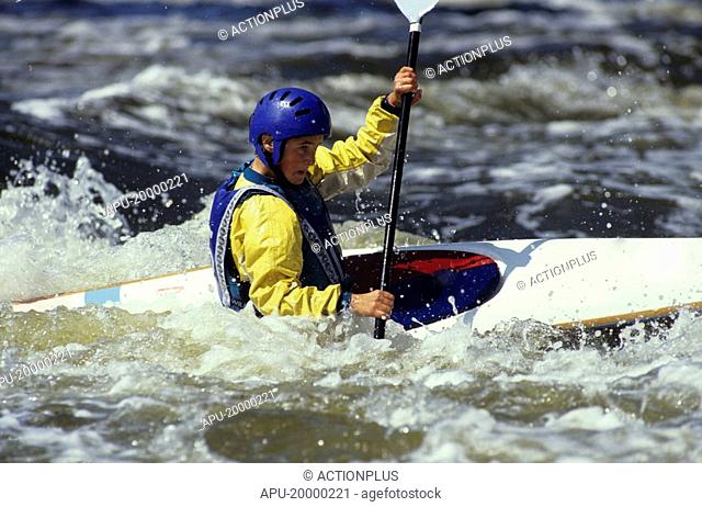 Teen kayaking through whitewater