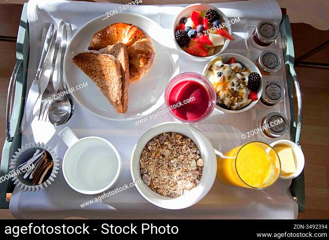 weißes Tablett mit einem gesunden Frühstück mit Müsli, Obst, Saft