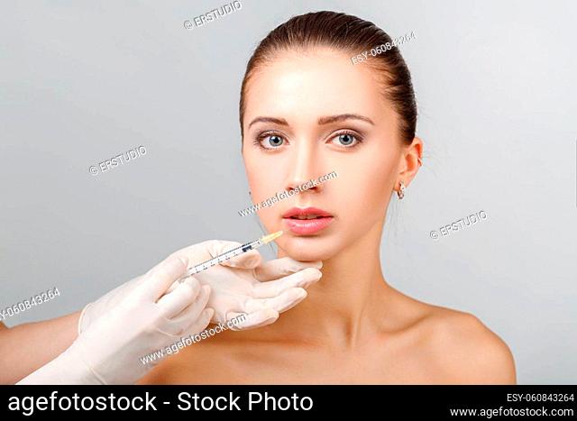 Portrait of young beautiful woman getting cosmetic lifting injection in face. Plastic Surgery. Cosmetic Treatment