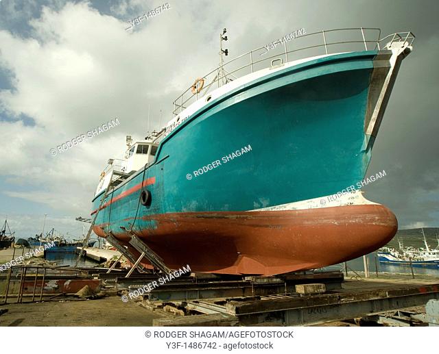 A fishing trawler on the slipway being prepared for a new coat of paint