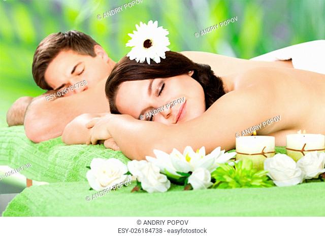 Relaxed young couple lying side by side at beauty spa