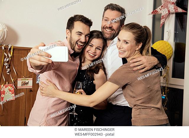 Friends taking selfies with smart phone on New Year's Eve