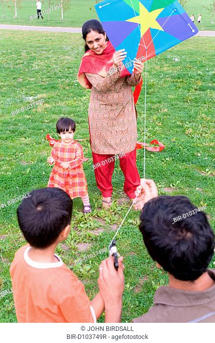 Young family in the park flying a kite