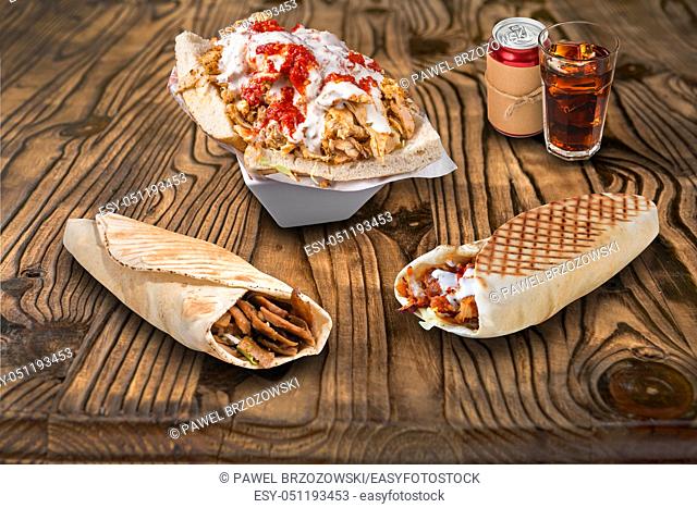 Doner kebab, pita sandwiches and cola on wooden background. For fast food restaurant design or fast food menu