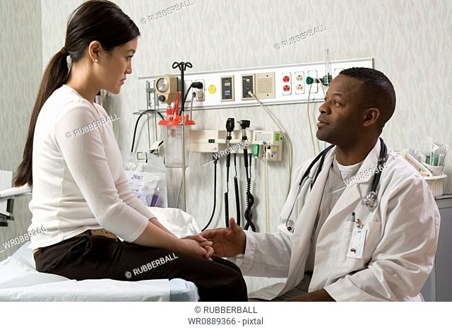 Profile of a male doctor talking to a young woman