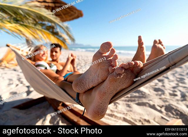 Caucasian couple lying on a hammock at the beach