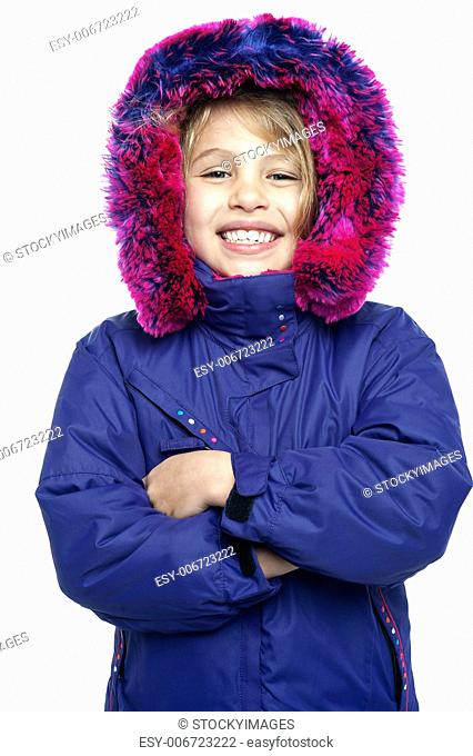 Sweet little girl in warm clothing standing with arms crossed