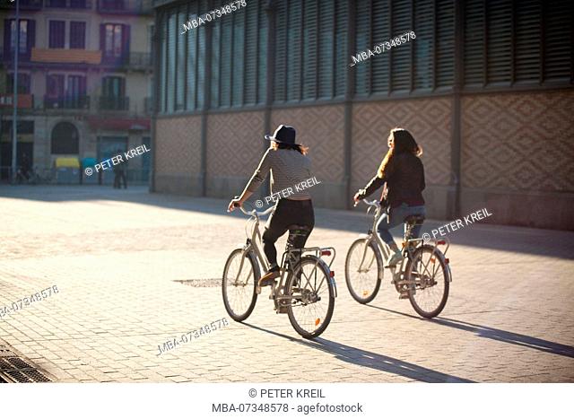 Two young women by bicycle in Barcelona, Catalonia, Spain