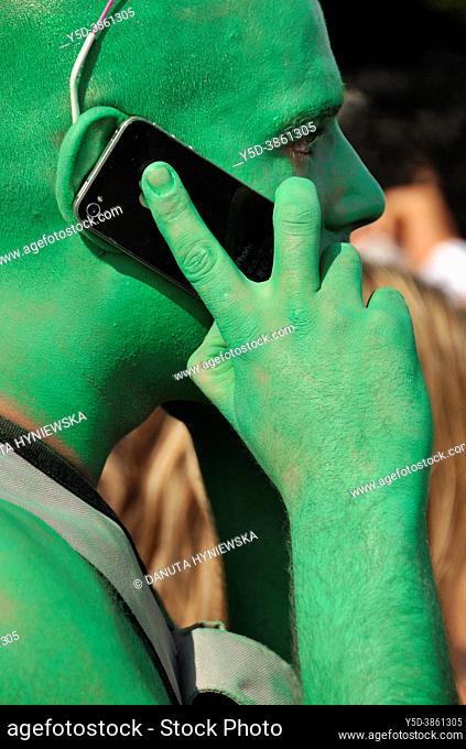 Portrait of young man, man's face painted in green colour, taken during Lake Parade - LGBT Parade, Pride Parade, city center of Geneva, Switzerland, Europe