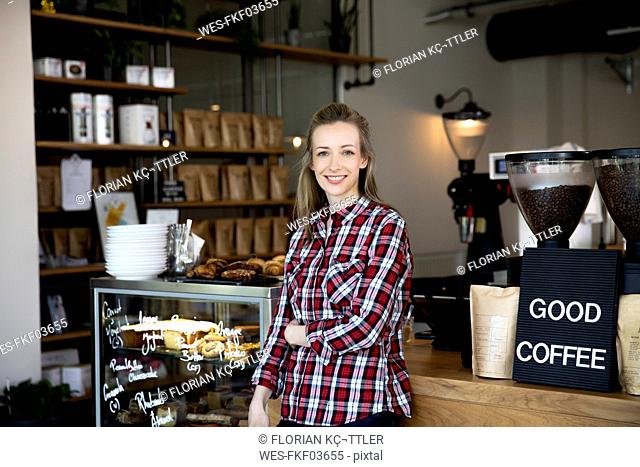 Portrait of smiling woman at the counter of a cafe