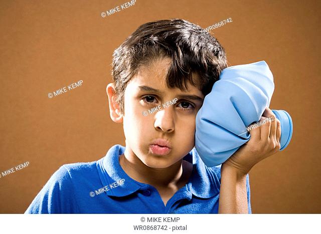 Boy holding ice pack to head