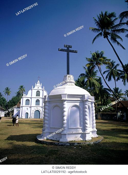 The Church of Our Lady in Hope on Vypeen Island, with a white monument in front and church behind, and palm trees against a blue sky