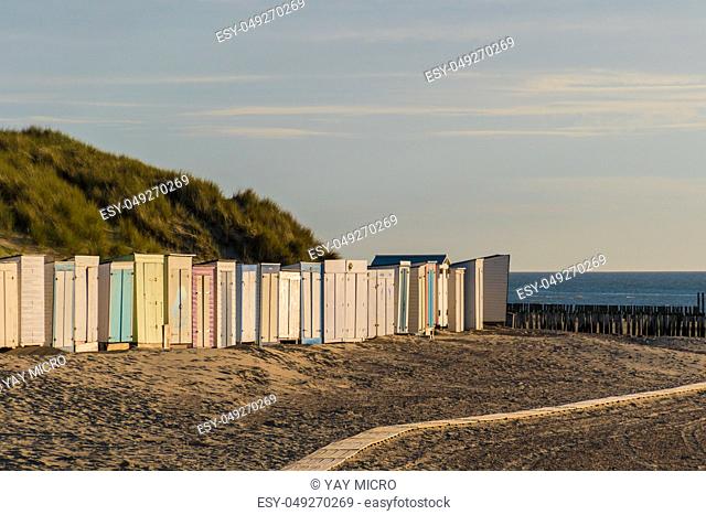 Colorful sheds at the beach in front dunes sunset