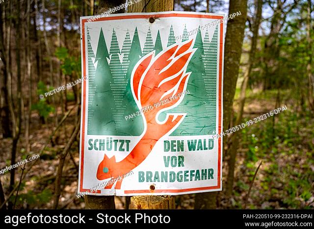 10 May 2022, Mecklenburg-Western Pomerania, Zirkow: A sign with the inscription ""Protect the forest from fire danger"" hangs in a forest on a forest path