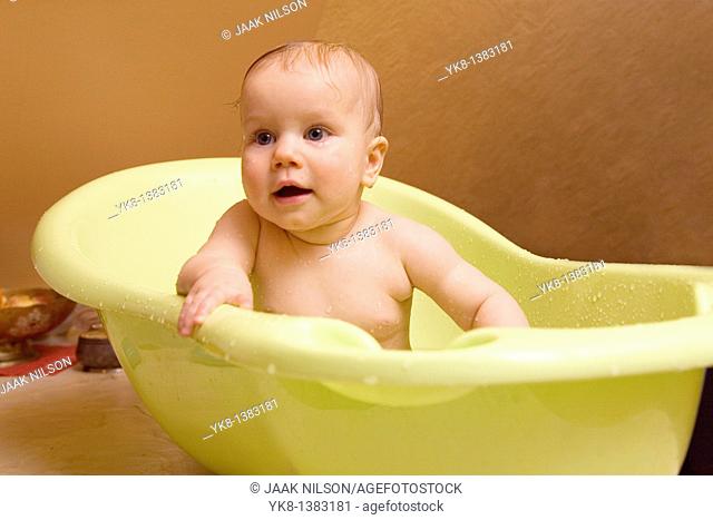 Happy Smiling Eight Month Old Infant Girl Taking Bath in Bathtub