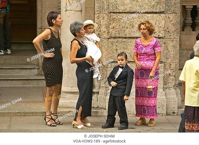 Family setting with little Rickie in a Tuxedo preparing to enter event in Old Havana, Cuba
