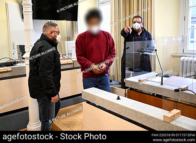 18 March 2022, Baden-Wuerttemberg, Ravensburg: A 31-year-old defendant (M) enters the courtroom in handcuffs. The defendant is accused of rape in combination...