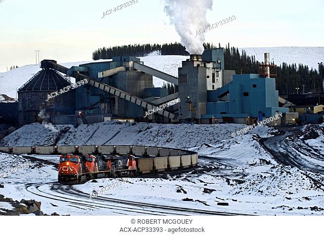 A working coal plant and a train being loaded with coal in the Alberta foothills, Canada