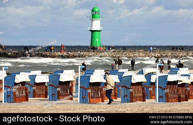 12 October 2021, Mecklenburg-Western Pomerania, Warnemünde: There are still many beach chairs on the Baltic Sea beach, they are now allowed to stay until the...