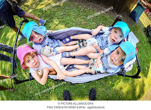 24 August 2019, Hessen, Lich: The two-year-old quadruplets Maja (l-r), Bruno, Paul, Oskar from Giessen sit in their little cart at the triplet meeting of the...