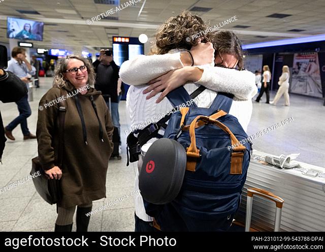 12 October 2023, Hesse, Frankfurt/Main: Relatives and friends are in each other's arms after the landing of an evacuation flight at Frankfurt Airport