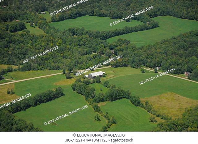 Anaerial photos shows farm lands, mountains, and farms